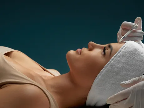 A woman receiving a cosmetic injection to her forehead